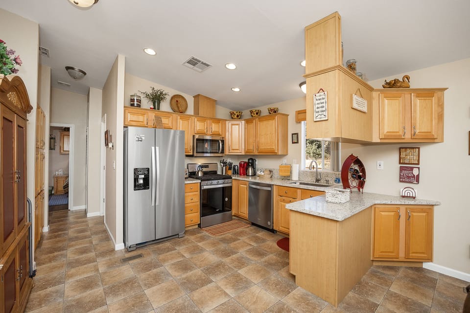 Bright functional kitchen with new Stainless Appliances, water and ice in door.