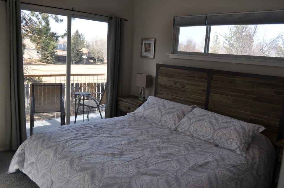 Master bedroom opens to balcony overlooking open space and mountain peaks