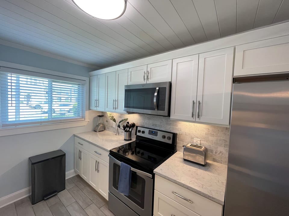 Kitchen with marble counter tops and full size refrigerator/freezer & ice maker