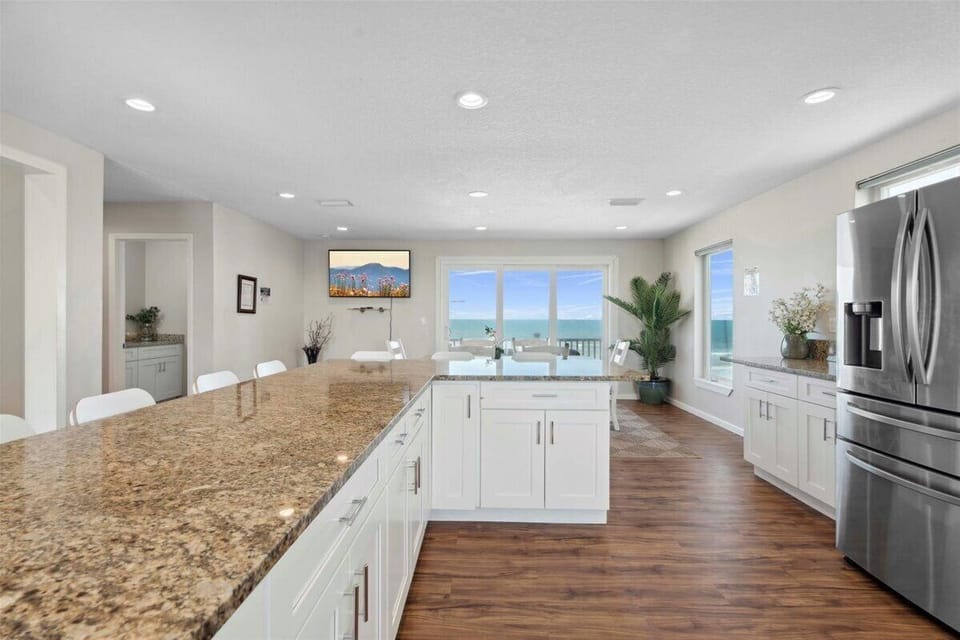 Oceanfront kitchen with island seating and panoramic beach views. 🌊🍽️