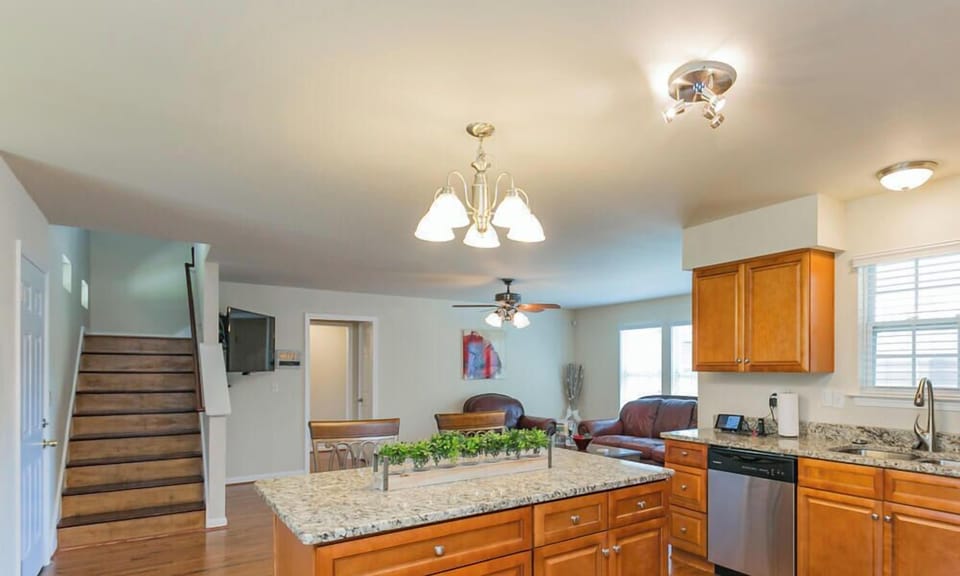 Large kitchen with granite top island open concept to living room with 60in tv 