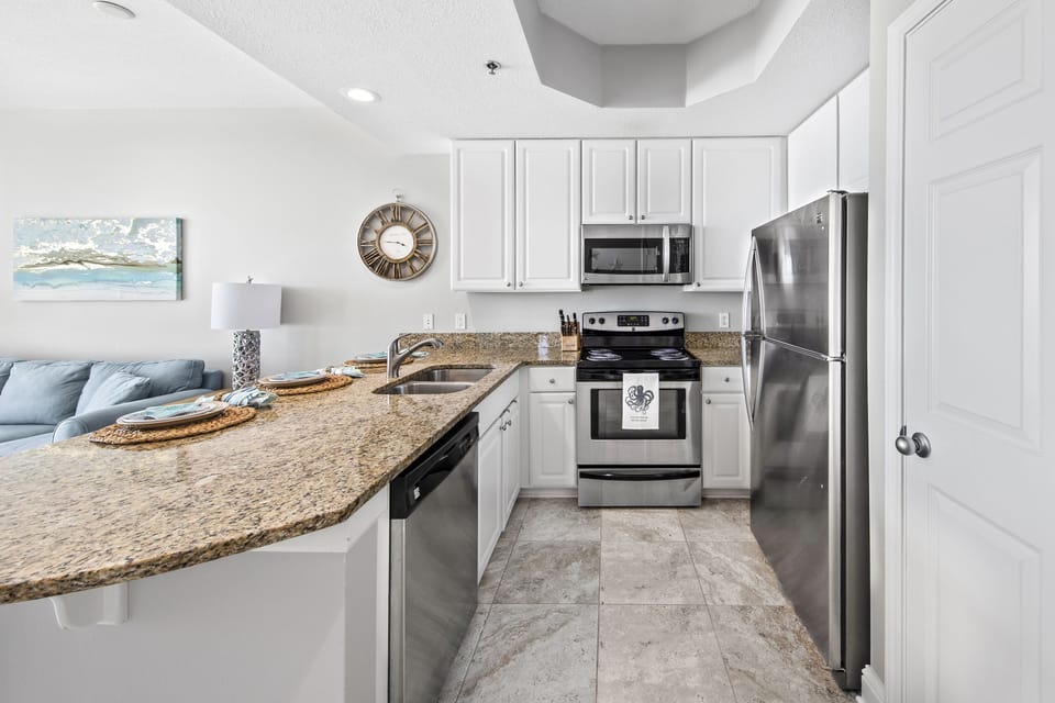 Fully stocked kitchen with stainless steel appliances.
