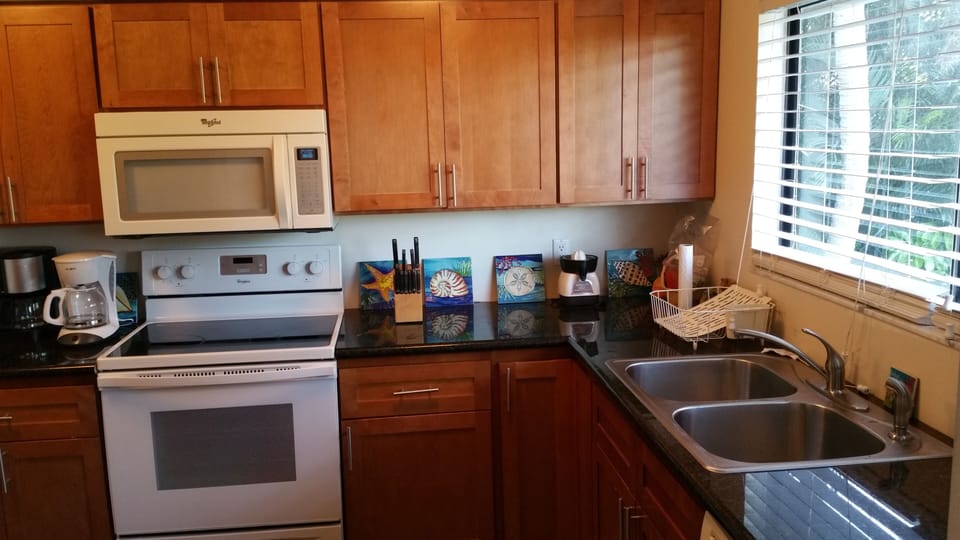 Spacious kitchen with window overlooking swimming pool, gardens and golf course.