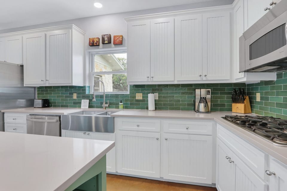 As you enter the home, this is the view of the kitchen to the right showing the farm house sink and counter space.  Recessed lighting provides plenty of lighting for food preparation.