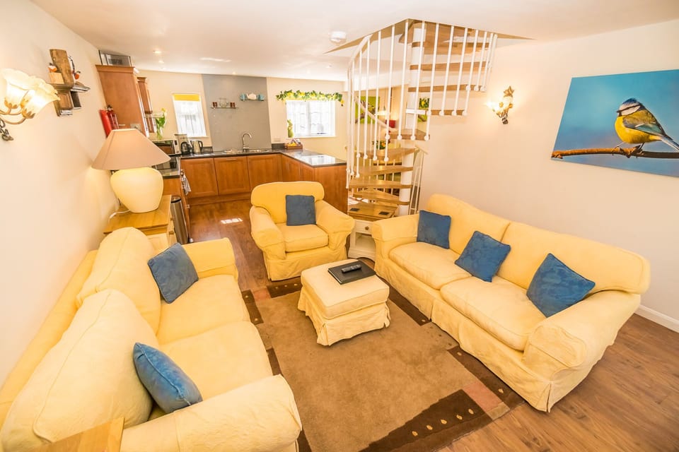 The living area is open plan with a large smart TV. The sofas can sit 6 people. A cupboard is full of board games and toys.
