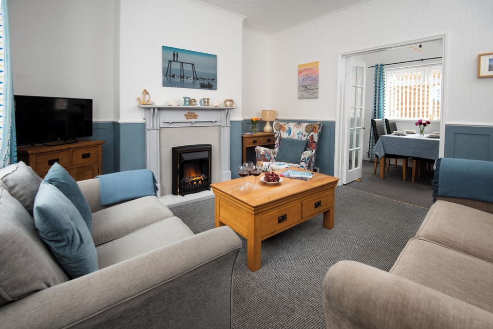 Relax in a cosy, open-plan lounge by the sea, perfect for family moments.