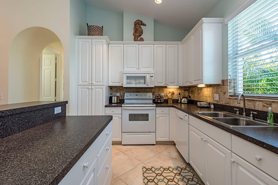 Fully equipped bright kitchen with center island. Toaster, blender, Keurig, etc.