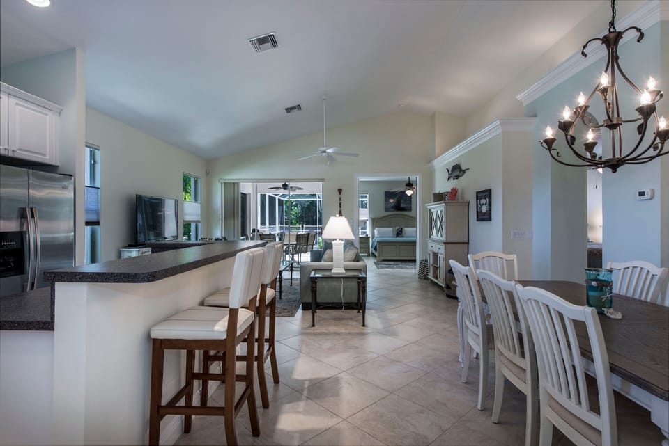 View of breakfast bar, dining area on right, great room with vaulted ceiling