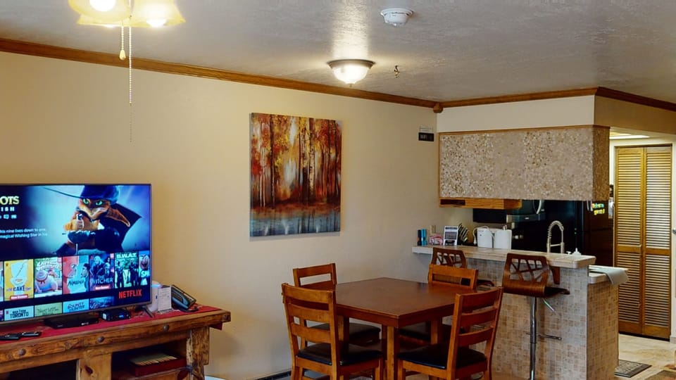 Large dining room table with excellent view of 55" TV.