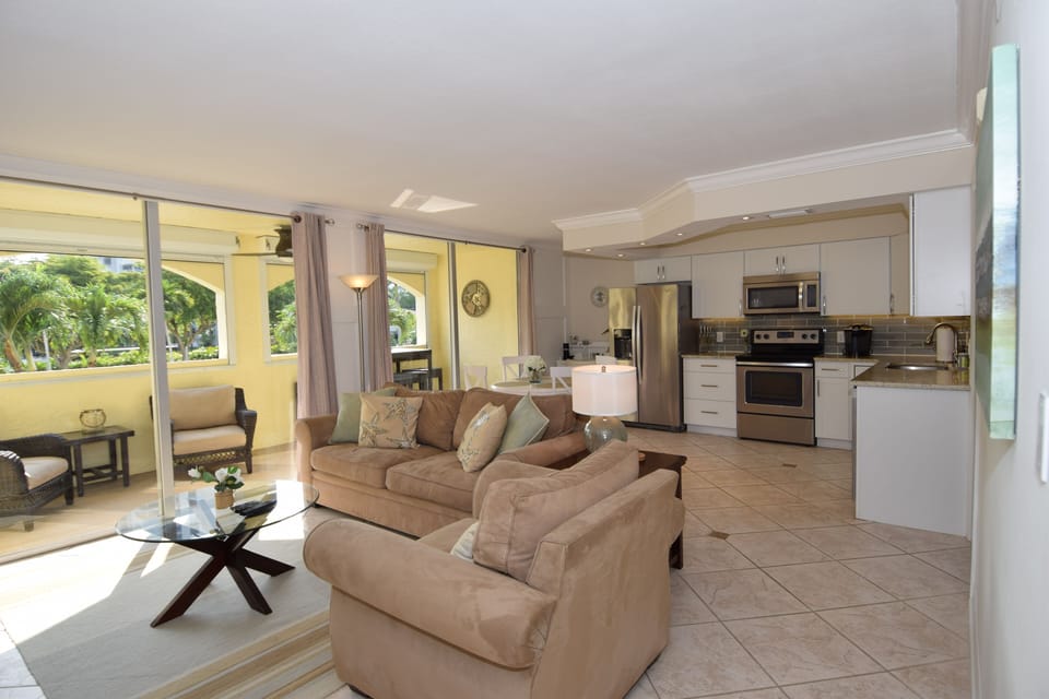 Modern coastal living space, open to kitchen, dining area and outdoor balcony. 