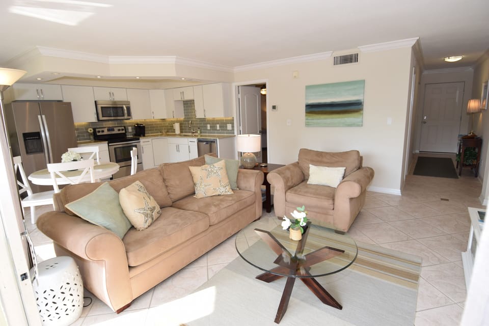 The costal living area with Pottery Barn furniture and glass table. 