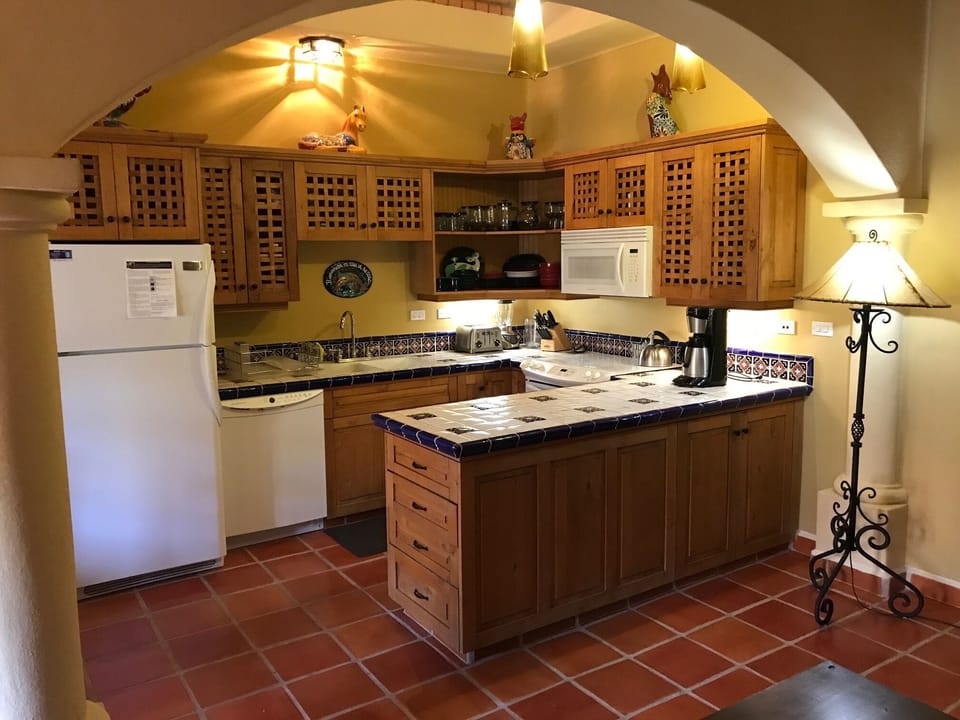 Kitchen with all cooking utensils, dinner & glassware.