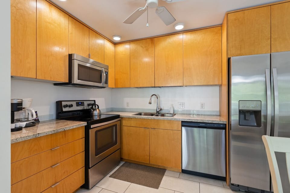 Clean kitchen w/ warm wood cabinets & stainless appliances ready for easy meals.