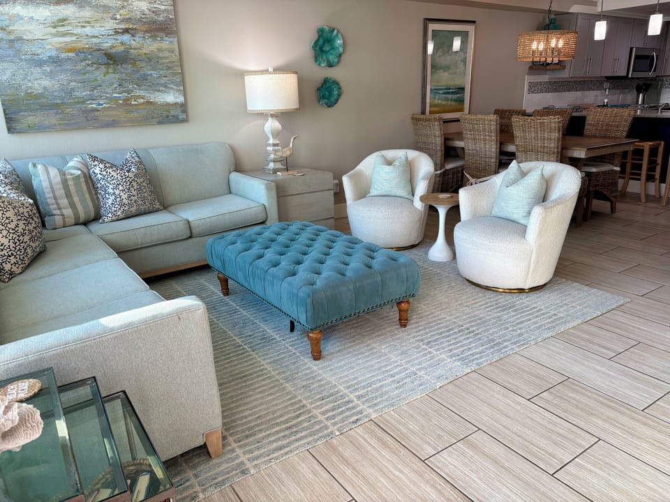 Comfortable coastal living area with large sectional and two swival chairs.