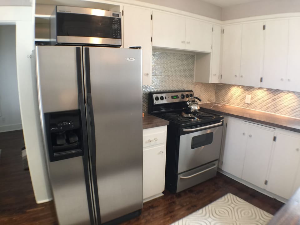 Stainless appliances and a new glass backsplash meld vintage and modern.
