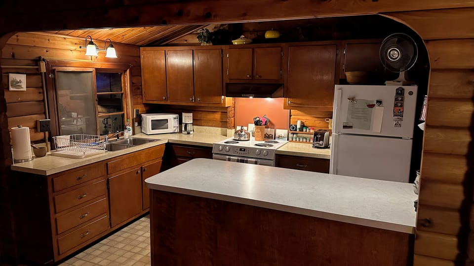 Kitchen with recent appliances and an  illuminated foodprep / serving island 