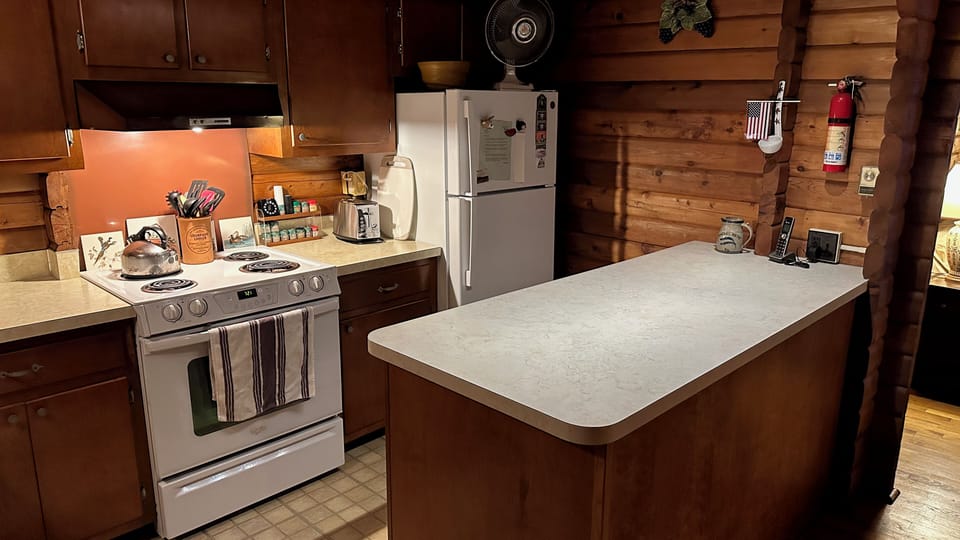 Kitchen with recent appliances and an  illuminated foodprep / serving island 