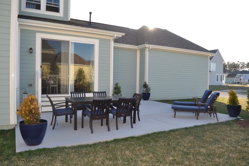 Large patio with a dining table that seats 6, as well as 2 loungers.