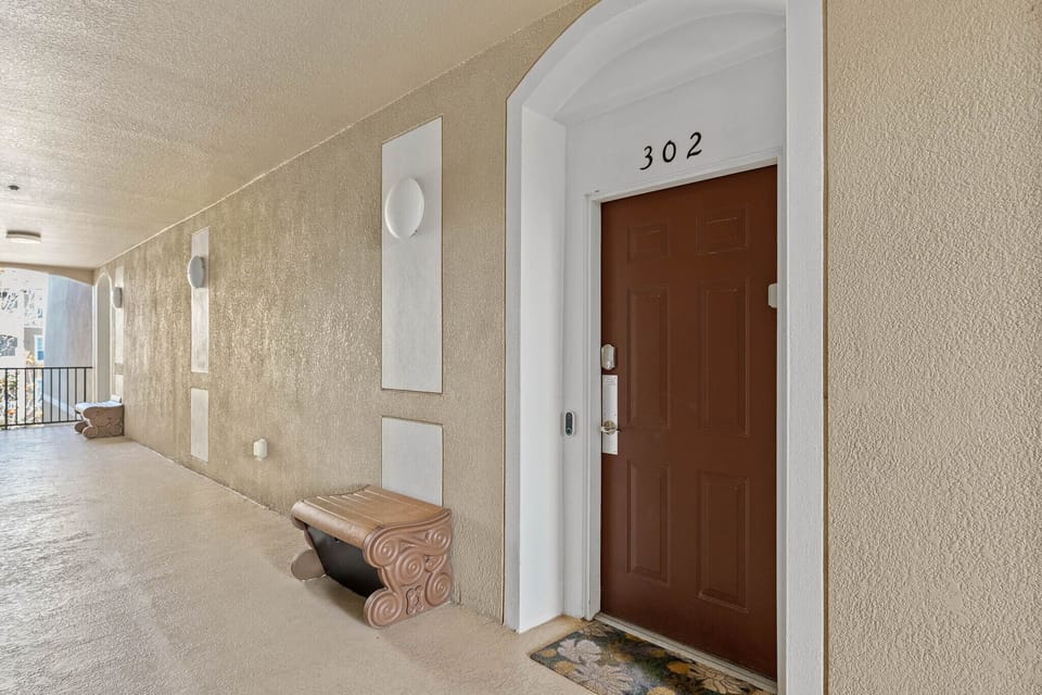 Condo front door with valet garbage at the brown bench.