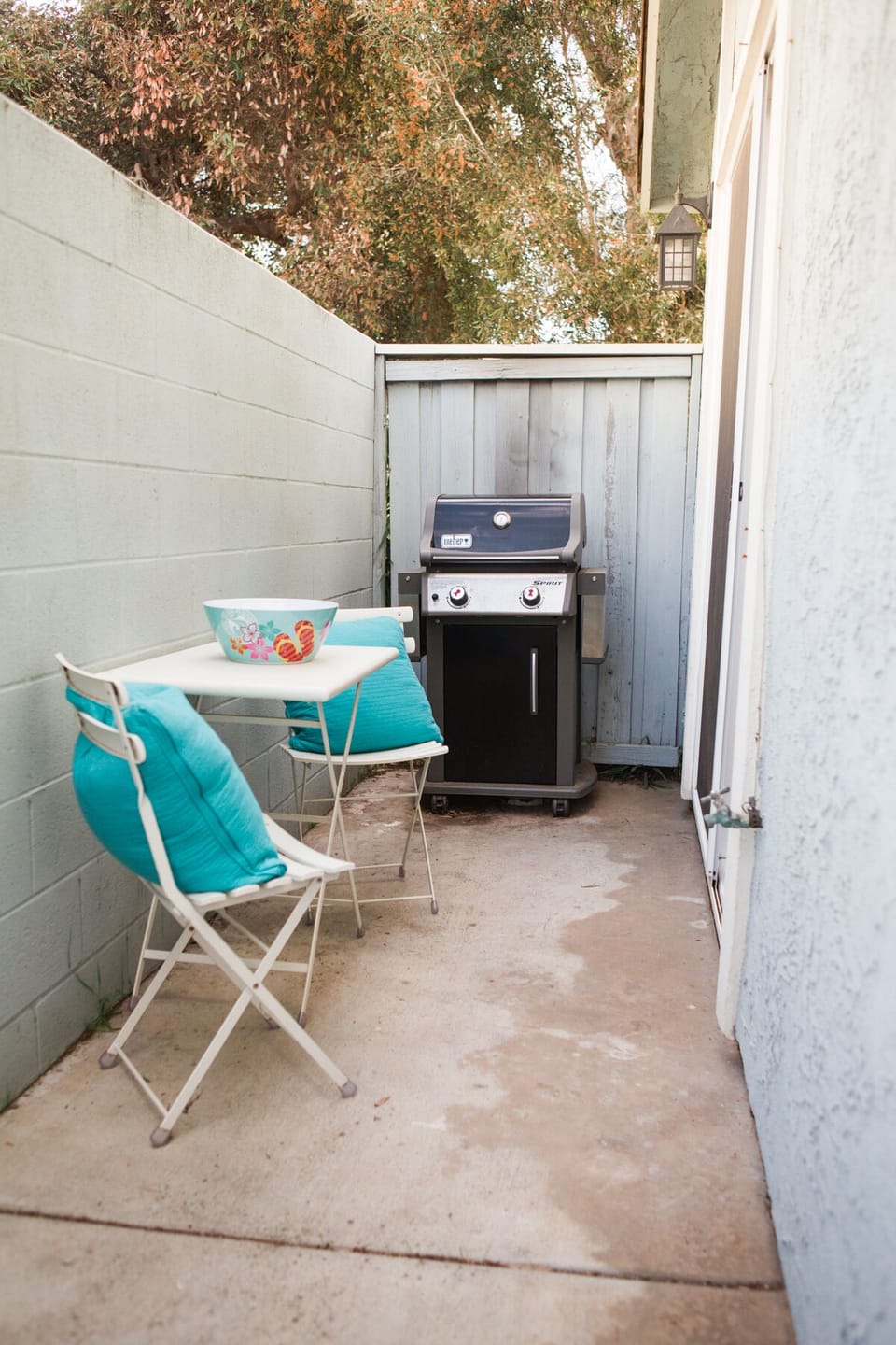 Side patio with gas BBQ and table to eat al fresco
