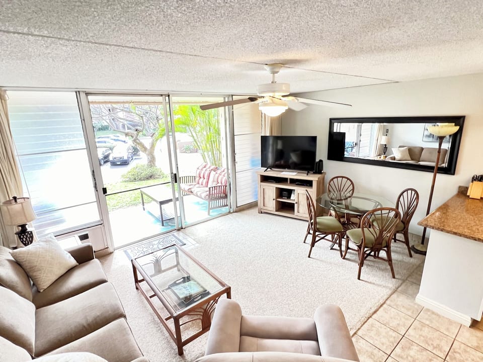Carpeted living room, smart TV,  cozy recliner and sliding door to the lanai.