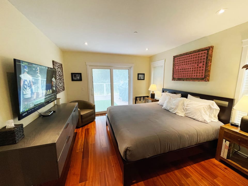 Primary bedroom with 55" TV and sliding doors to upper deck and views.
