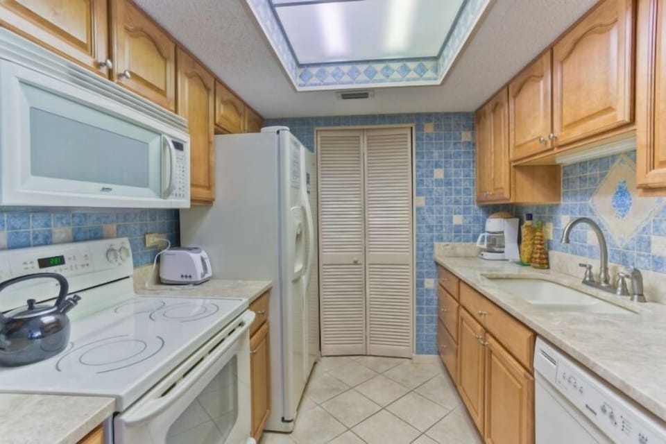 Beautiful tiled kitchen with granite counter tops and updated appliances. 