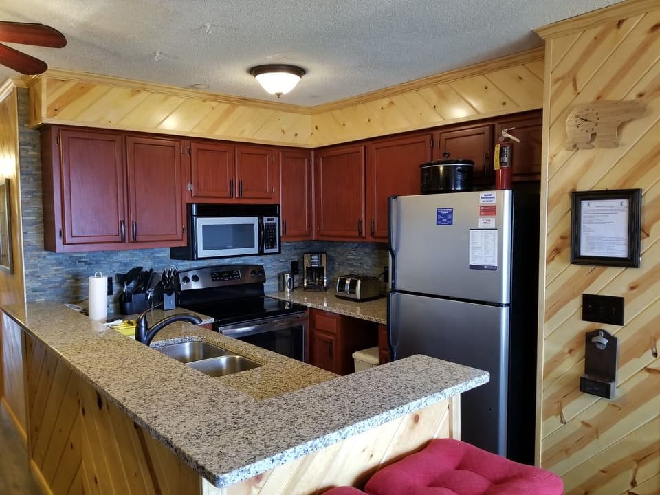 kitchen with stove,  microwave,  fridge, dishwasher, toaster,  coffee pot.