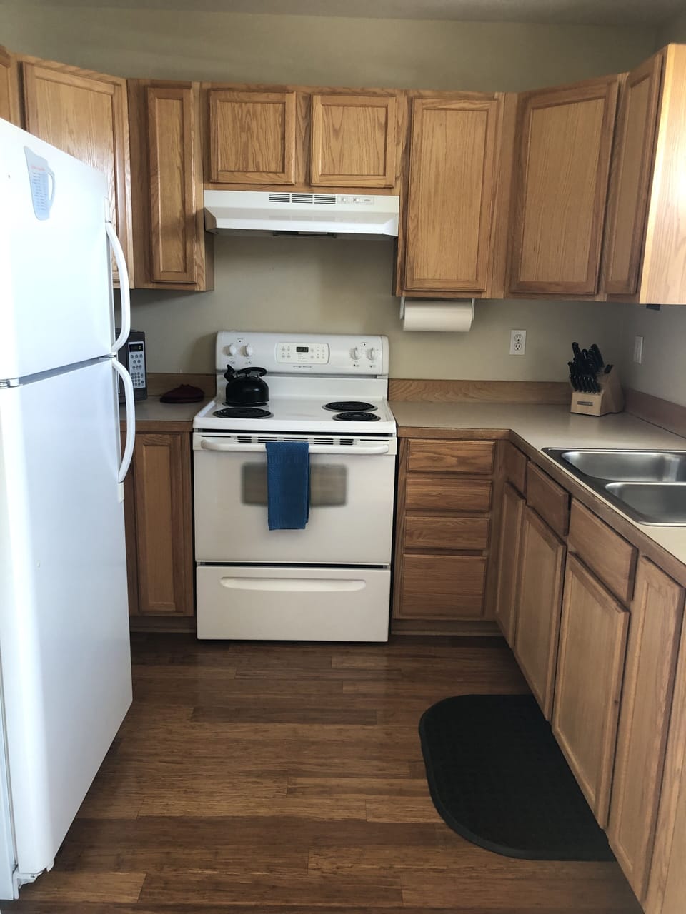 Kitchen equipped with microwave, drip coffee maker, blender, electric range. 