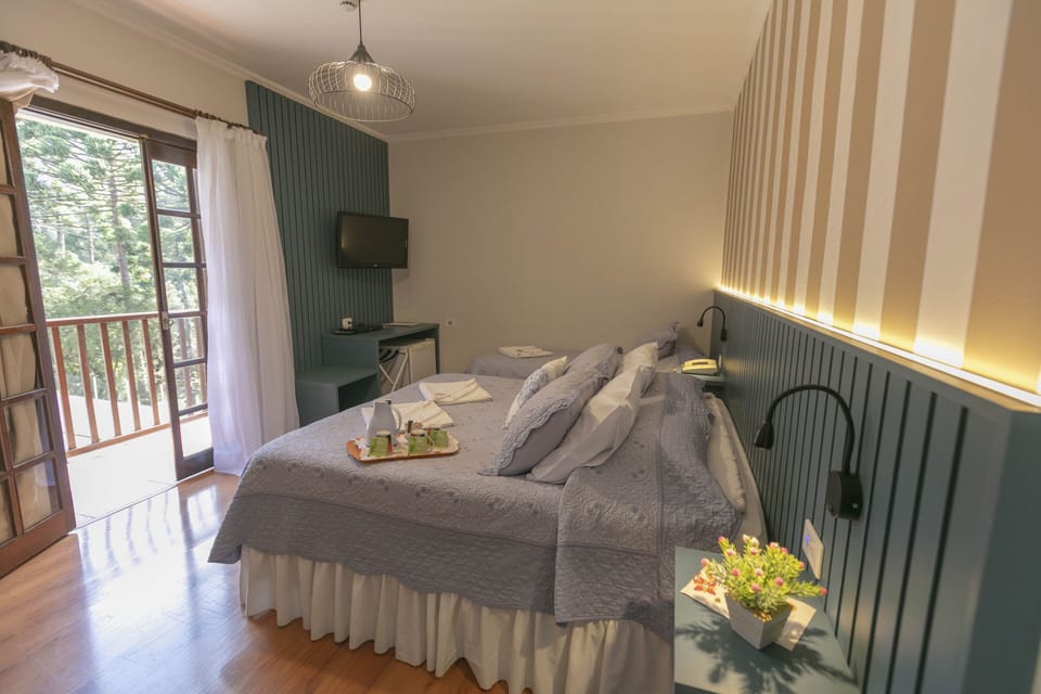 Quarto Luxo Triplo | Minibar, in-room safe, desk, blackout drapes