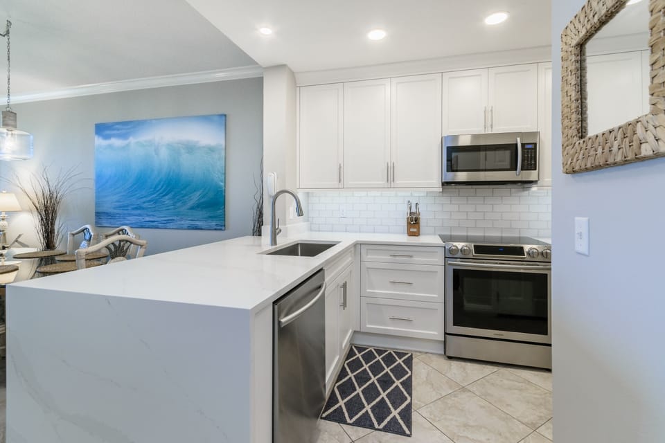 Quartz waterfall edge bar opens to the dining room.