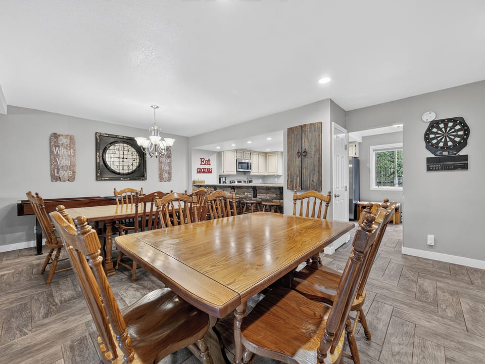 Gather your group around this spacious dining table for meals and laughter, with a game room and well-equipped kitchen steps away for your convenience.