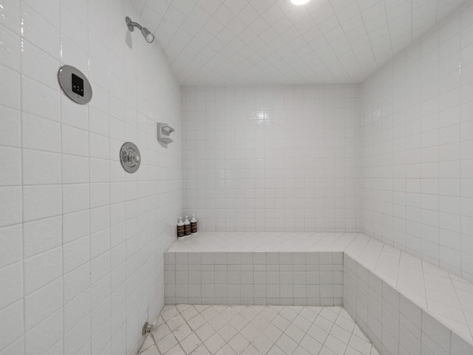 Relax under your private rainfall shower in this spacious, pristine tiled bath. The built-in bench and dual showerheads offer spa-like comfort after exploring the day.
