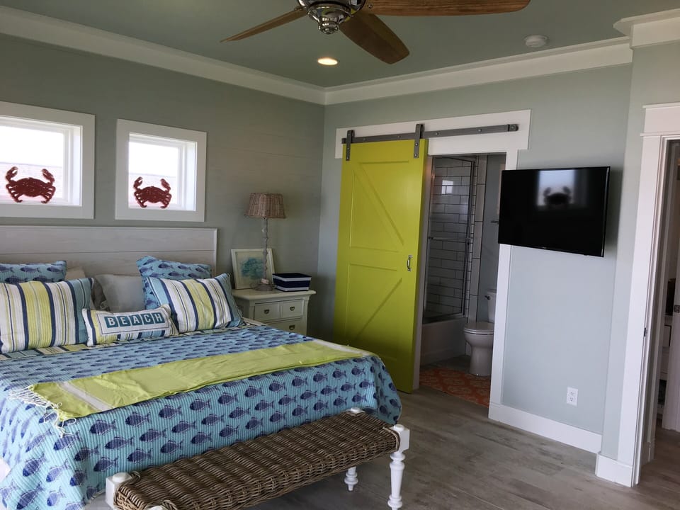 Upstairs King bedroom, with twin bunk beds, Smart TV, and shared bathroom.
