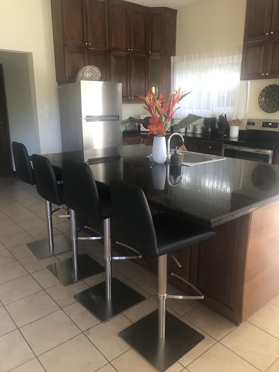 Downstairs an open-concept kitchen, stainless steel appliances & Island w/stools