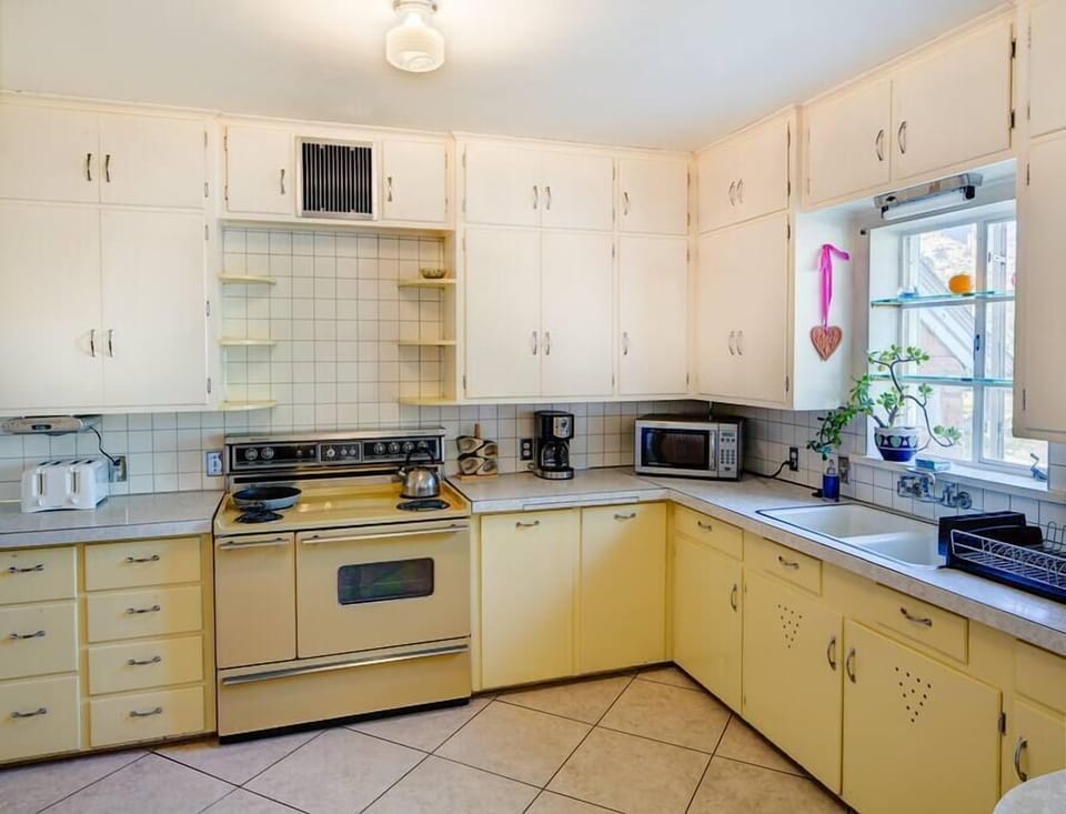 Kitchen with Plenty of counter space and storage. Appliances, coffee maker and  various kitchen tools. Cutlery, tableware wine glasses, juice glasses pots & pans