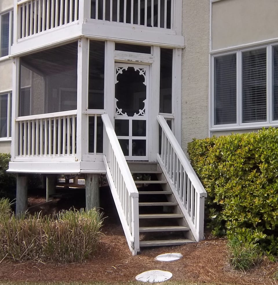 Screened porch with private stairs to lawn, pool, and  ocean beyond.
