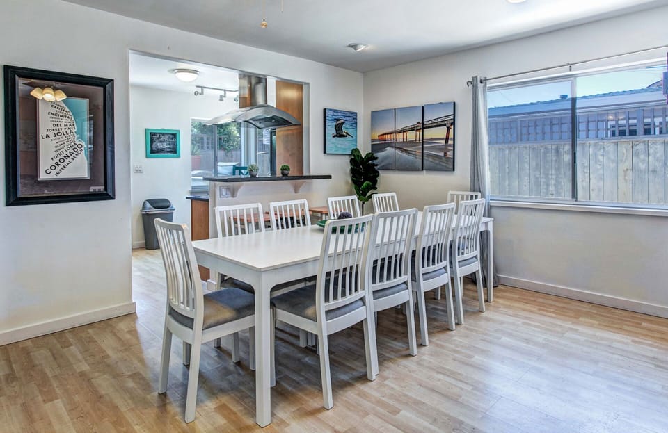 A large dining table comfortably seats 10 guests, making it perfect for family dinners, holiday gatherings, and shared meals after a relaxing day at the beach.