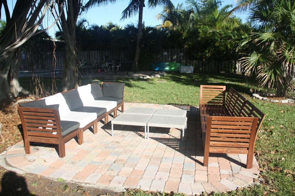 Lounge by canal with part of backyard and kayaks in the background