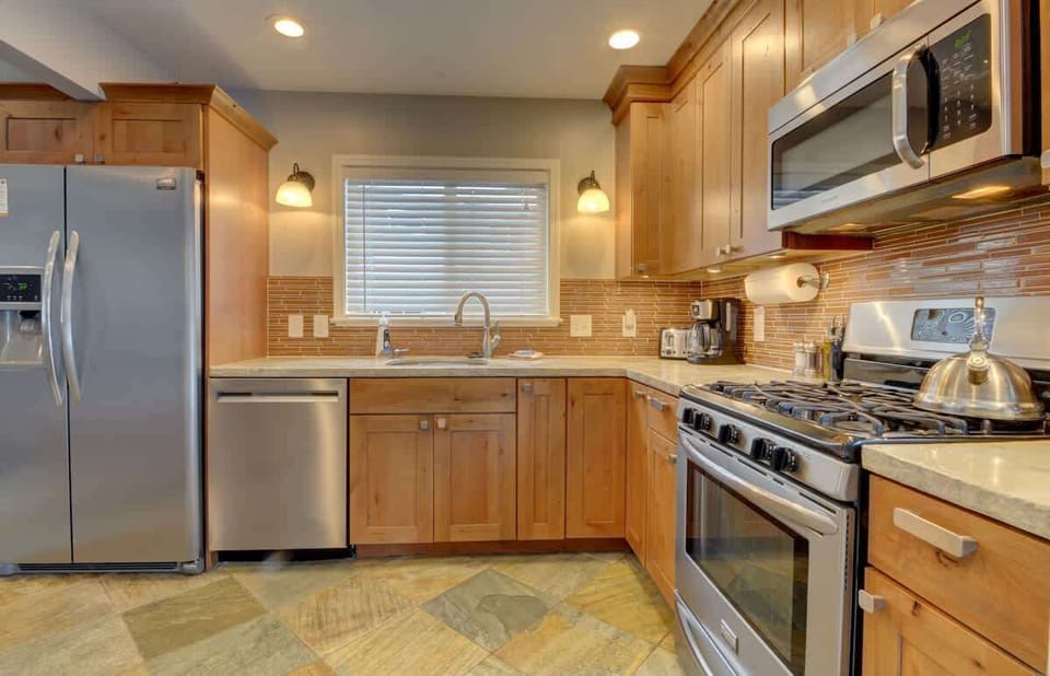 Fully stocked open concept kitchen. Plates, glasses, mugs, kids plated, cutlery, bowls, cookware, pots and pans, dish towels, small appliances included 