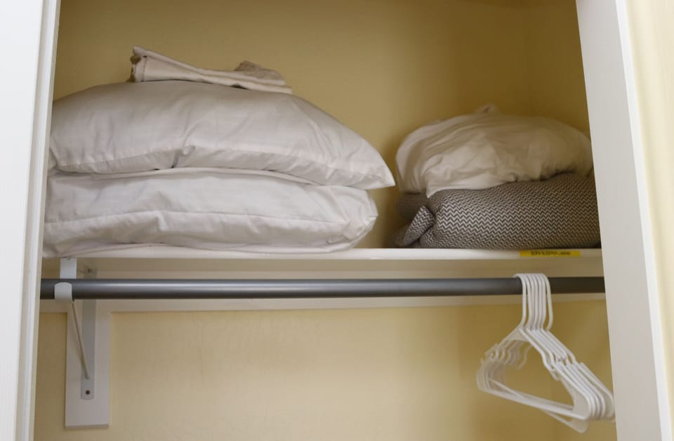 Full size sofa-sleeper linens and extra pillows are stored in the second bedroom