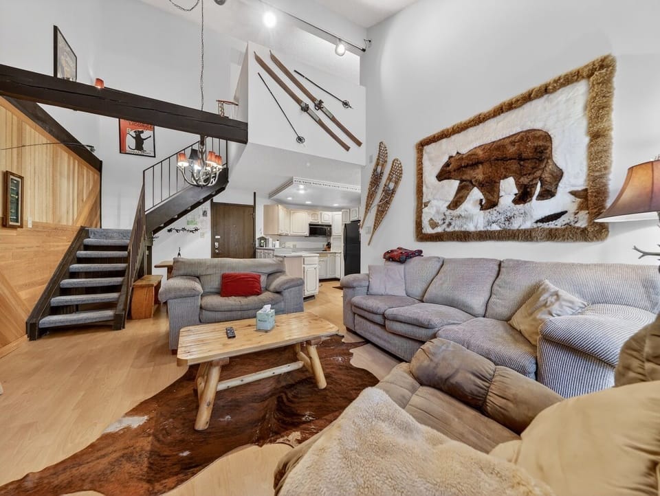 Cozy mountain lodge vibes welcome you with plush seating, rustic wood accents, and charming ski décor in this inviting open-concept space.