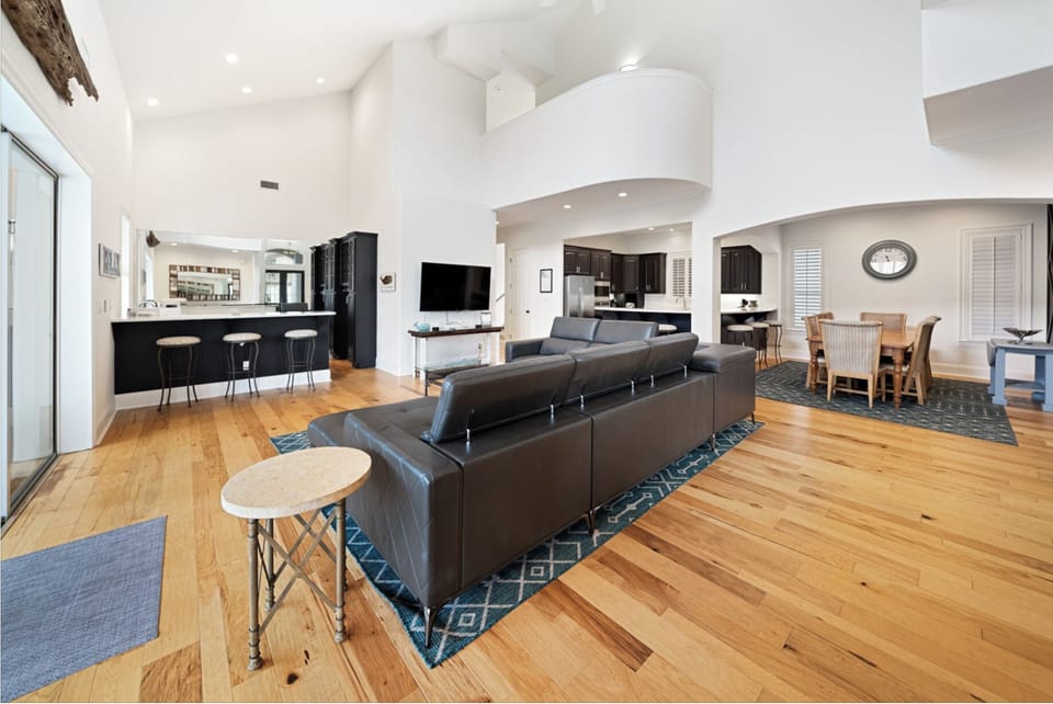 Step into your spacious open-concept haven, where sleek leather seating and warm hardwood floors create the perfect backdrop for memorable gatherings.