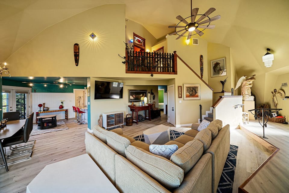 Large open floor plan with a soaring ceiling and 65" smart Fire TV.