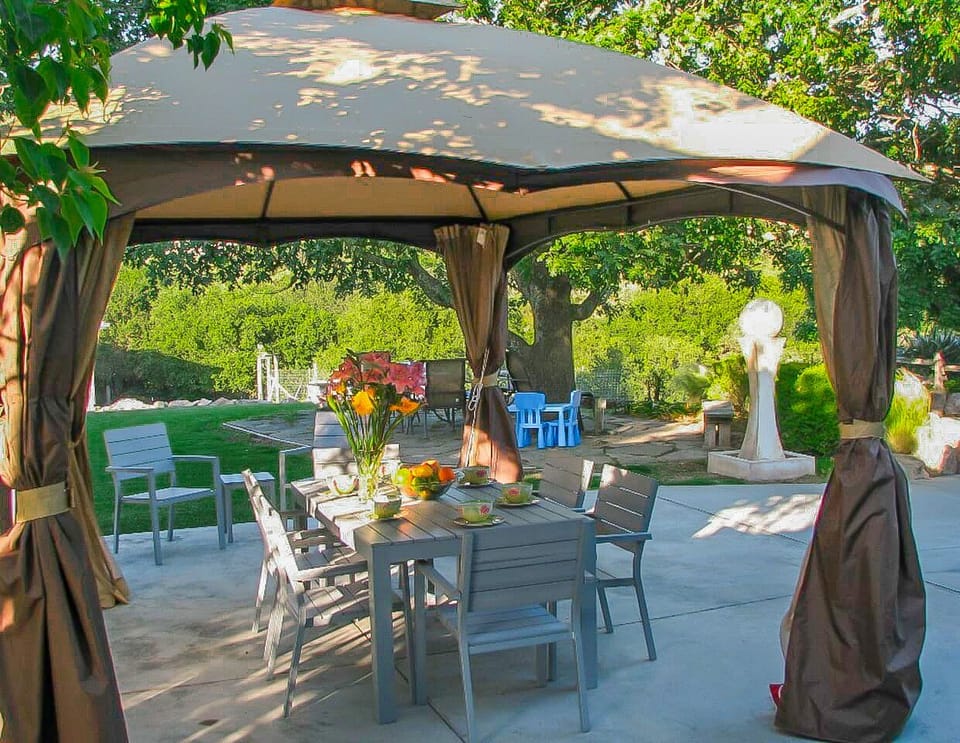 Covered outdoor dining area with lighting. 