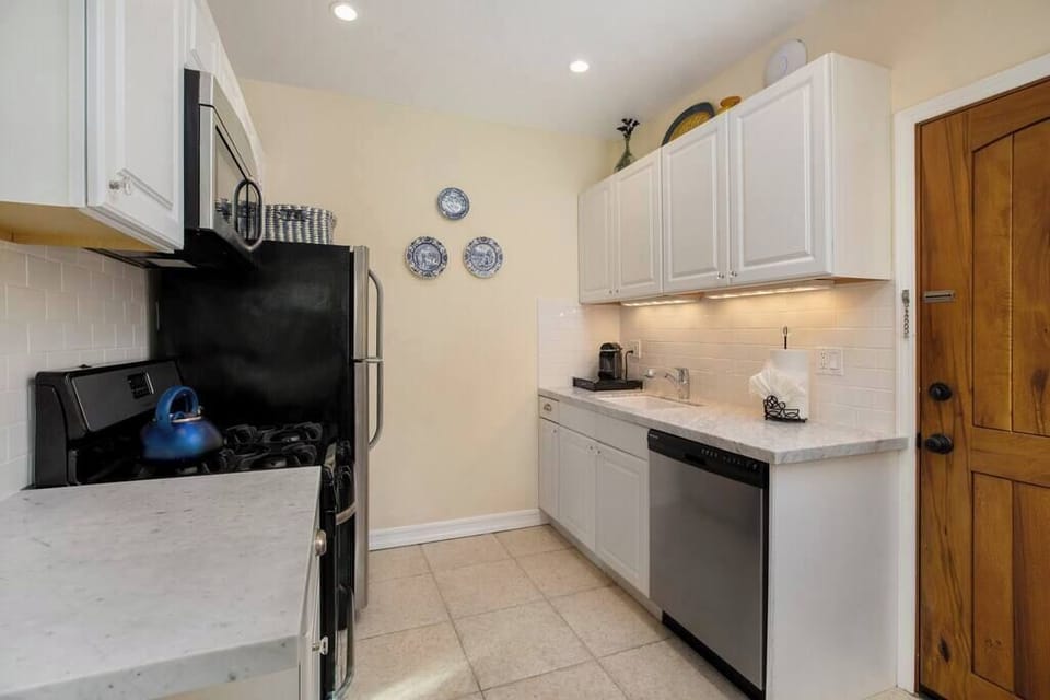 The kitchen is elegantly accented by Carrera marble and limestone surfaces.
