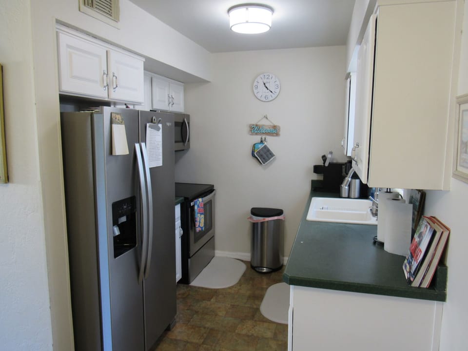 Full kitchen with ice and water dispenser, full-sized range and OTR microwave.