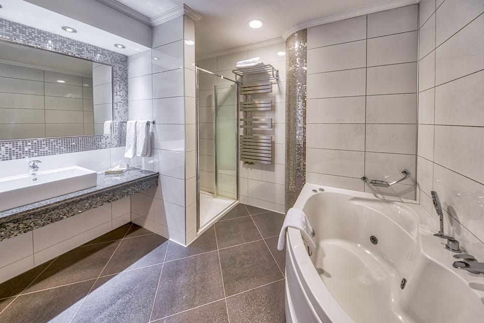 Deluxe Room, 1 King Bed | Bathroom | Rainfall showerhead, eco-friendly toiletries, hair dryer, bathrobes