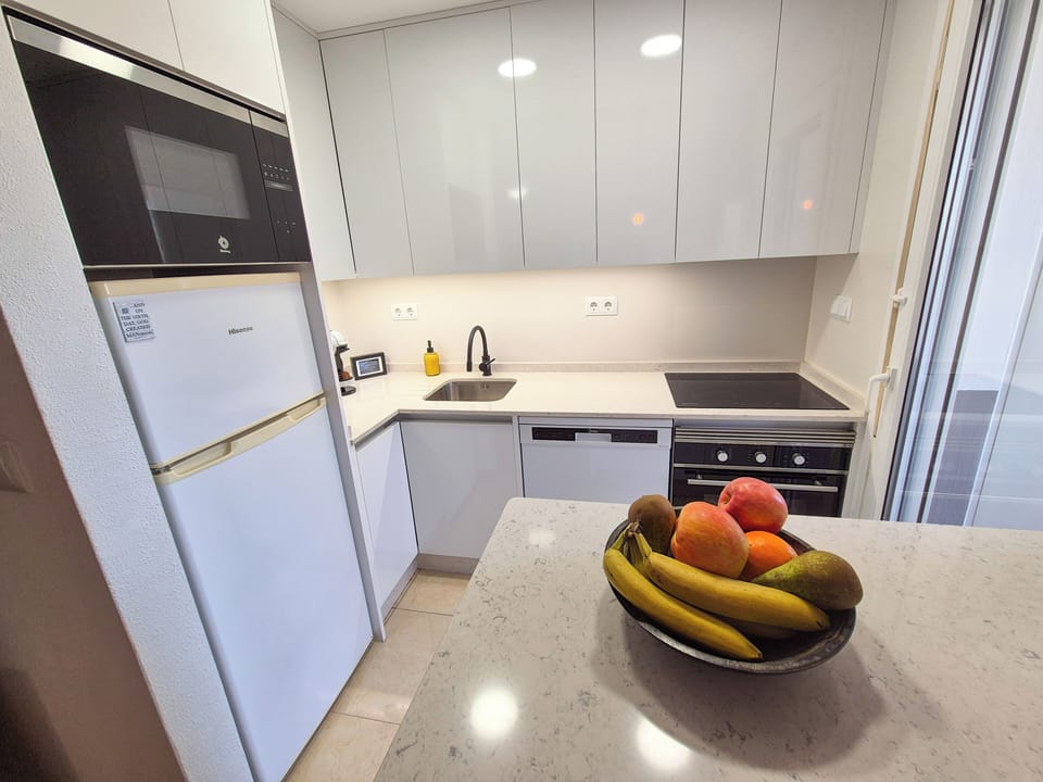 Kitchen, with dishwasher, induction hob, extractor fan, oven and fridge freezer.