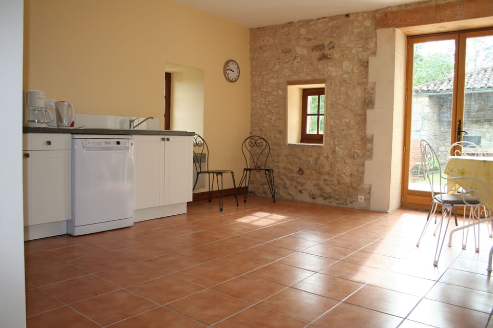 Light kitchen with patio doors leading to outdoor terrace on one level